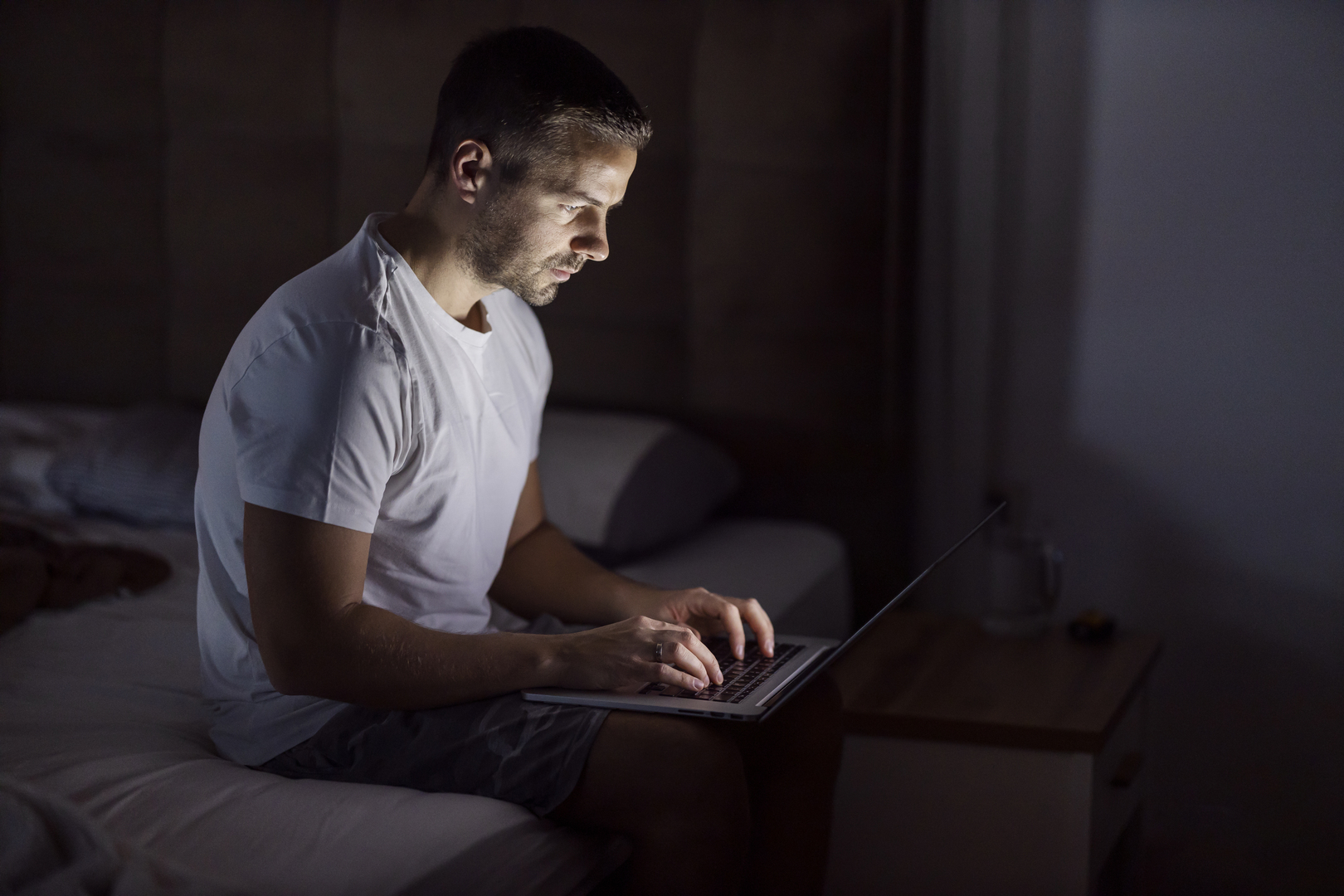 Young man using a laptop at night.