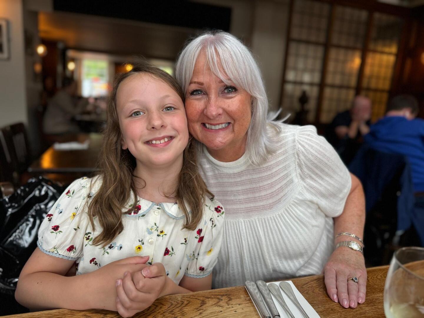 Woman and child smiling together at a restaurant.