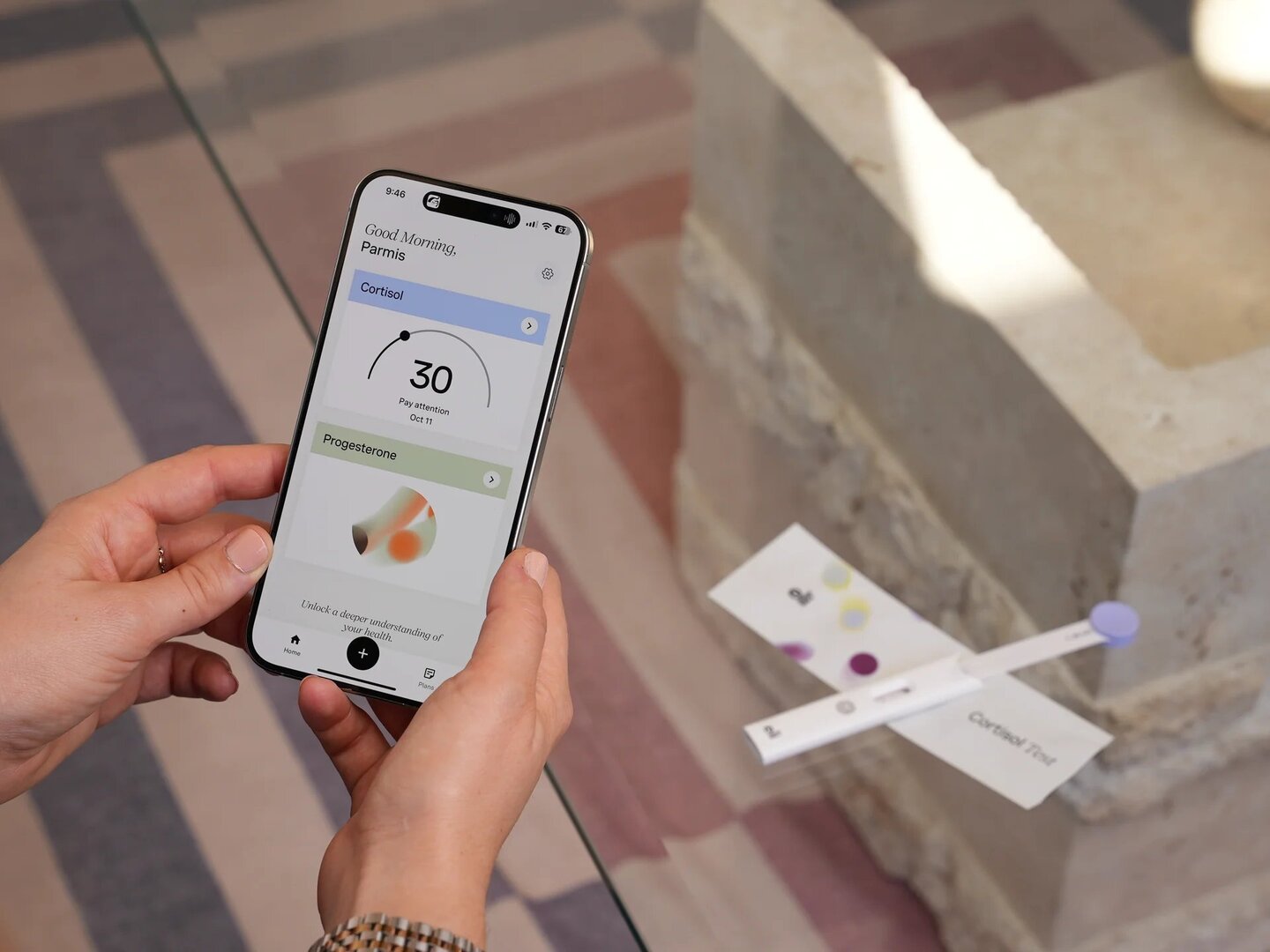 Person using a smartphone app to view cortisol and progesterone test results.