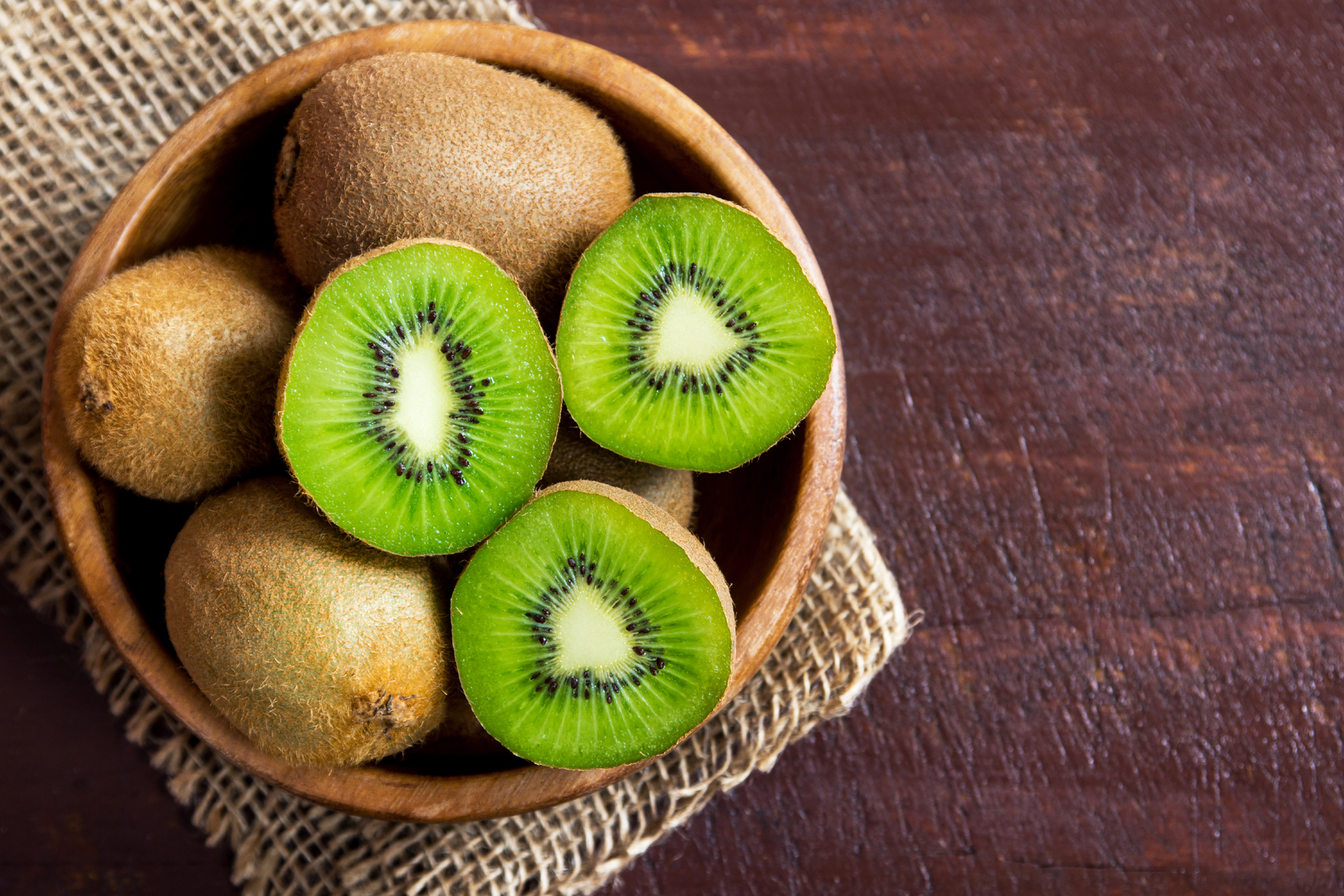 Kiwi fruit in a wooden bowl.